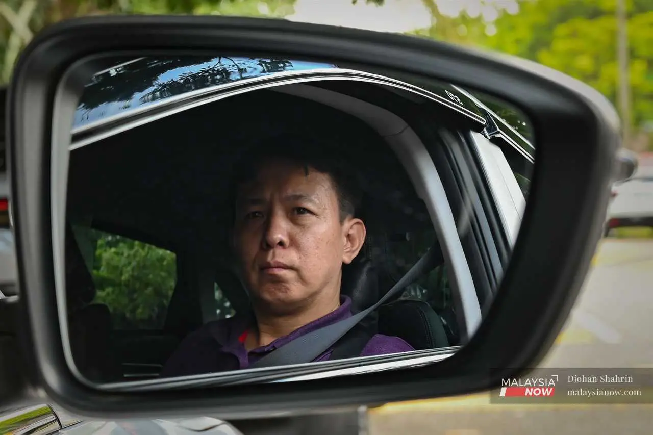 Mr. Ong looking through the side mirror